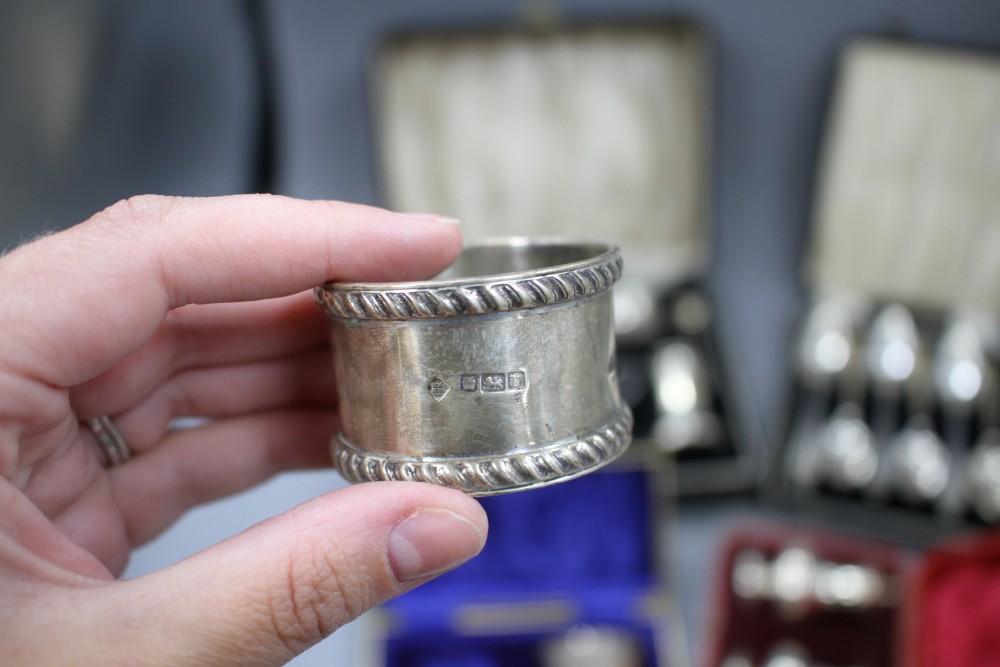 Four cased sets of silver, including pair of napkin rings, six grapefruit spoons, condiment set and pair of pepperettes.